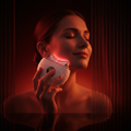 Woman using a red light device on her face with a dark background